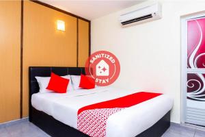 1 dormitorio con 1 cama con almohadas rojas en Super OYO 756 Muar City Hotel, en Muar