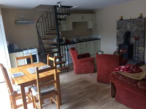 uma sala de estar com uma mesa e uma escada em espiral em Walkers Lodge em Broadford