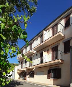 un edificio con balcones y un cielo azul en Hotel Bed Sandalia, en Badesi