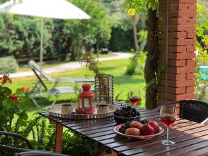 a wooden table with a plate of fruit and wine glasses at Gialos Villas 1-2 With a Private Pool in Mikros Gialos