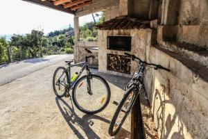 due biciclette parcheggiate sul lato di un edificio in pietra di Rural Accommodation Veselic a Pridvorje