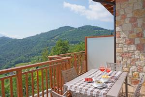 una mesa con comida y copas de vino en el balcón en Agriturismo Hegemone, en Tremosine Sul Garda