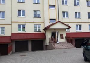 a building with two garage doors in front of it at Apartament dwupoziomowy in Augustów