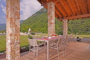 una mesa y sillas en un patio con una montaña en Agriturismo Hegemone, en Tremosine Sul Garda