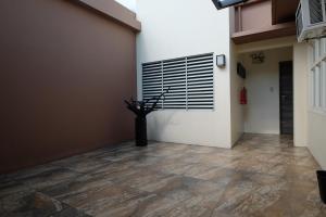 a hallway with a tile floor and a white wall at Oriental Zen Suites in Manila