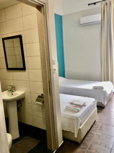 a hotel room with two beds and a sink at Hotel Kastoria in Thessaloniki