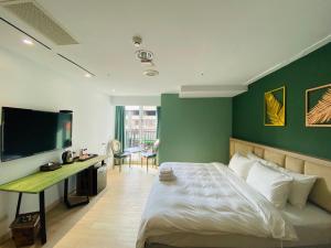 a bedroom with a bed with a green wall at Taichung EnrichLife Hotel in Taichung