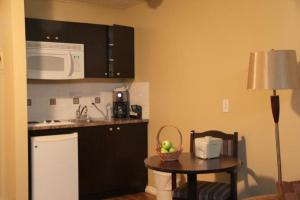 a kitchen with a small table and a microwave at Acorn Motel in Grande Cache