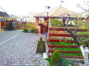 ein roter Zaun mit einem Pavillon in einem Hof in der Unterkunft VirDi House in Morschyn