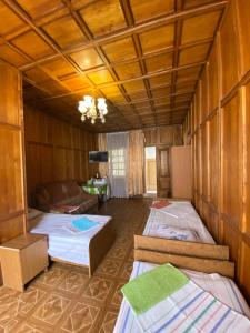 アドレルにあるGuest House Mikhailのベッド3台とソファが備わる部屋