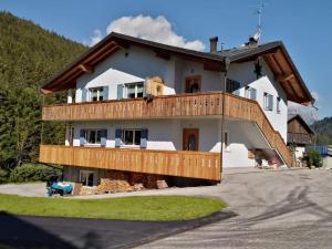 a large house with a wooden deck on a driveway at B&B DeBy & E-Bike Rental in San Niccolò Comèlico