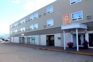 a large building with a motel sign on the side of it at Acorn Motel in Grande Cache