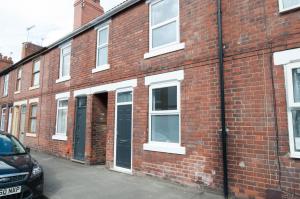 a red brick building with a black door at The Comet - 5 separate beds & 3 bathrooms in Burton upon Trent