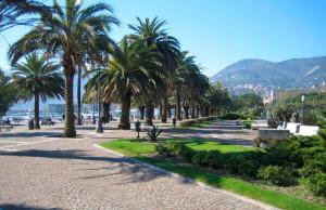 einen Park mit Palmen und einem Strand und Bergen in der Unterkunft Da Vici in La Spezia