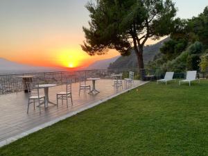 a deck with tables and chairs and a sunset at Il Saretto in Sarno