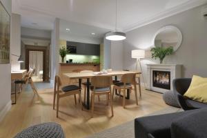 a living room and kitchen with a table and chairs at STRADONIA Serviced Apartments in Krakow