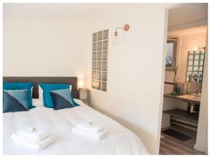 アヴィニョンにあるAventure Avignonnaise - ROOFTOP TERRASSE - INTRAMUROS - CITY CENTERのベッドルーム(白いベッド、青い枕、シンク付)