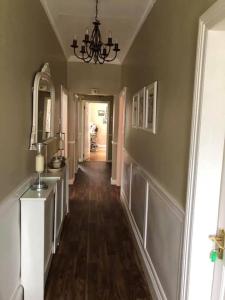 um corredor de uma casa com um lustre em Oak Lodge Portumna em Portumna