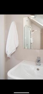 Oak Lodge Portumna في بورتومنا: حمام أبيض مع حوض ومرآة