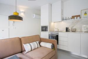 een woonkamer met een bank en een keuken bij Oporto Sweet Home II in Porto