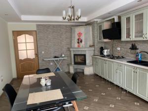 eine Küche mit einem Tisch und einem Kamin in der Unterkunft VirDi House in Morschyn