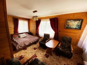 ラプカにあるWilla Światowidのベッドルーム1室(ベッド1台、テーブル、椅子2脚付)