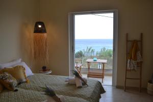 a bedroom with a bed and a large sliding glass door at Sole Verde in Agios Georgios