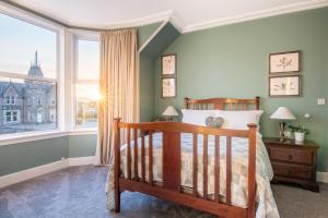 a bedroom with a bed and a large window at West of the Ness - City Centre Home with 5 Bedrooms in Inverness