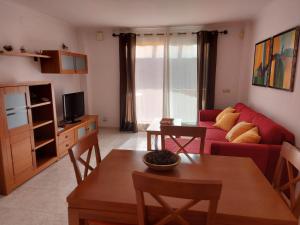 a living room with a red couch and a table at Paraíso in Cumbre del Sol