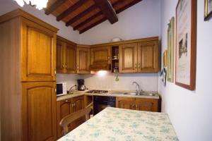 a small kitchen with wooden cabinets and a table at La Renaia in Cortona