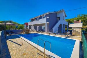 a swimming pool in front of a house at Holiday Home Zen in Primorski Dolac