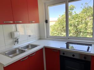 a kitchen with red cabinets and a sink and a window at Villa Orca in Podaca +62 photos