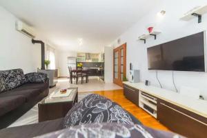 a living room with a couch and a large flat screen tv at Holiday Home Zen in Primorski Dolac
