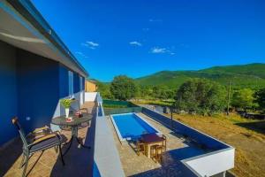 eine Terrasse mit einem Tisch und einem Pool in der Unterkunft Holiday Home Zen in Primorski Dolac