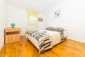 a bedroom with two beds and a wooden floor at Holiday Home Zen in Primorski Dolac +16 photos