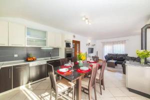 a kitchen and living room with a table and chairs at Holiday Home Zen in Primorski Dolac