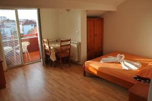 - une chambre avec un lit, une table et un balcon dans l'établissement Apartments Joce, à Ohrid
