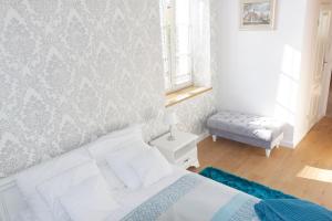 a white bedroom with a bed and a window at Apartamenty Hexus - Świdnicka - Wrocław centrum Rynek in Wrocław