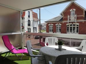 a patio with a table and chairs on a balcony at Le Saint Amand, studio cabine, agréable terrasse sud in Le Touquet-Paris-Plage