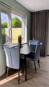 
a dining room table with chairs and a window at B&B In Het Slot in Veldhoven
