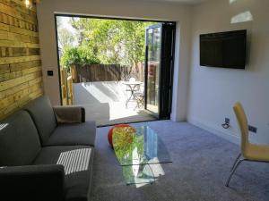a living room with a couch and a glass table at Derby Den by Cliftonvalley Apartments in Bristol