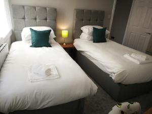 duas camas com toalhas num quarto em Derby Den by Cliftonvalley Apartments em Bristol