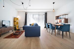 - un salon avec un canapé bleu et une table dans l'établissement Cosy Voltaire Residence, à Bruxelles