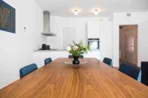 a dining room table with a vase of flowers on it at Cosy Voltaire Residence in Brussels