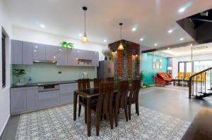a kitchen and dining room with a table and chairs at Tropical Villa Halong in Ha Long
