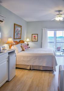 a bedroom with a large bed and a balcony at The Sunset Inn in Sunset Beach