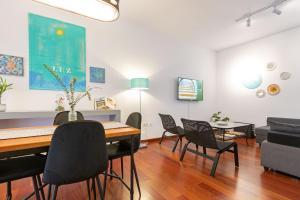 a dining room and living room with a table and chairs at Apartamento Madroño Regina in Seville
