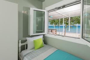 a small bedroom with a bed and a window at Boccatura in Skala Kallirakhis