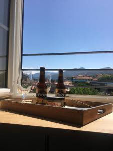 two bottles of beer and glasses on a tray in a window at CasaRadriimas, un cocon au cœur du Centre Ville in Propriano