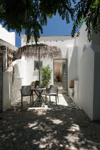 a patio with a table and chairs in front of a building at Archetypo 1855 - Villas and Suites in Naxos Chora